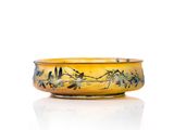 a yellow bowl with birds on it on a white surface