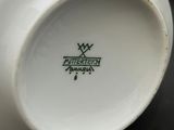 a close up of a white bowl with a green logo on it