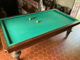 une table de billard sur laquelle se trouvent deux boules, dans une pièce