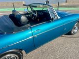 a blue convertible car parked on the side of the road