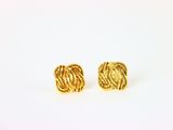une paire de boucles d'oreilles en or sur fond blanc