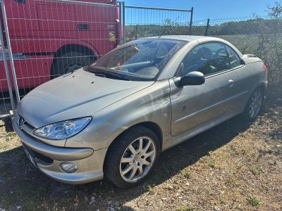 une photo d'une voiture argentée garée devant une clôture