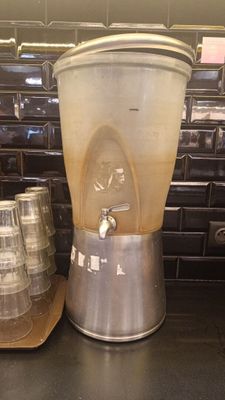 un mixeur posé à côté d'une pile de tasses sur un plan de travail