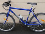 un vélo bleu garé devant un immeuble