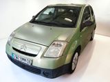 a picture of a small green car parked in a white room