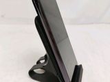 a close up of a cell phone on a stand on a table