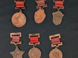 six medals and a star on a black background