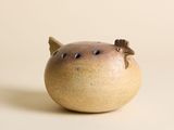 un petit vase avec un oiseau sur une table