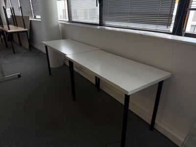 a long white table in a room with a window