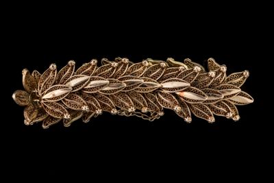 une photo en gros plan d'une broche en feuille d'or