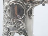a close up of a silver vase on a table