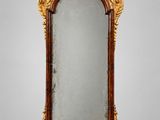 un miroir sculpté avec un cadre doré sur fond blanc