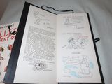 a book open on a bed with drawings on it