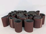 un gros plan sur un ensemble de ceintures marron posées sur une surface blanche