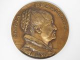 un gros plan sur une médaille de bronze représentant le profil d'une femme