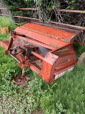 un vieux matériel agricole rouillé, abandonné dans l'herbe