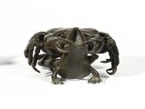 a small statue of a crab on a white surface