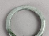 a close up of a green bracelet on a white surface
