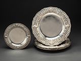 deux assiettes en argent et une assiette en argent sur fond noir
