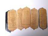 four pieces of leather are lined up on a white surface
