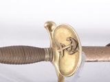 a close up of a sword with a gold emblem on it