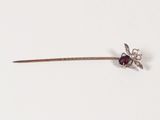un petit bâtonnet en argent orné d'une fleur rouge