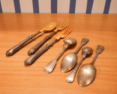 cinq cuillères, deux fourchettes et une cuillère sur une table