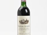 the bottle of wine is sitting on a white surface