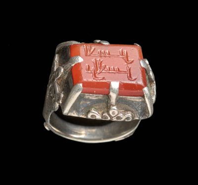 une image représentant une bague en argent avec une pierre rouge au centre
