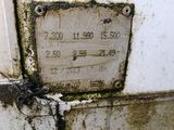 a dirty thermometer on the side of a building
