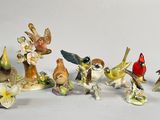 many figurines of birds that are sitting on a table