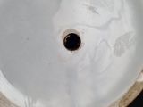 a close up of a white vase with a hole in it