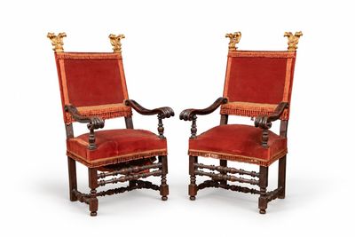 deux chaises rouges ornées de passementerie dorée et dotées d'une assise rembourrée rouge