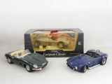 two toy cars are sitting in a box on a white surface