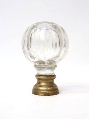a clear glass ball on a brass base