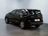 the black suv is parked in a large room with a white wall