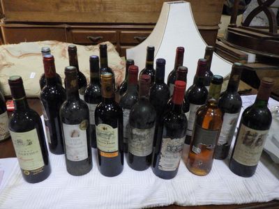 plusieurs bouteilles de vin posées sur une table à côté d'une lampe