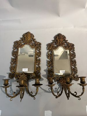 deux miroirs accrochés au mur à côté d'un lustre
