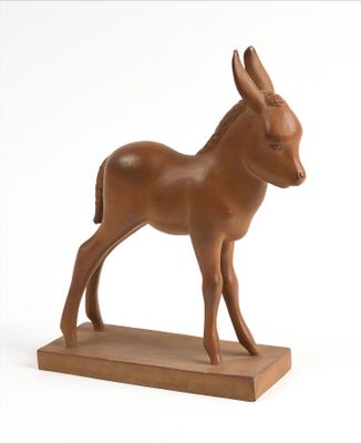statue d'un âne posée sur un socle en bois, sur fond blanc