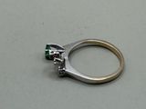 a close up of a ring with a green stone