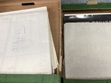Deux boîtes remplies de papiers sont posées sur une table dans une pièce.