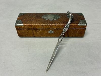 a small wooden box with a pair of scissors in it