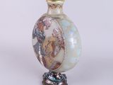 a vase with a picture on it sitting on a stand