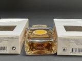 two boxes of perfume sitting next to each other on top of a table