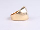 the gold ring is sitting on top of a white surface