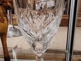 a wine glass sitting on a glass table in a glass case
