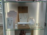 a glass display case with jewelry on it in a store