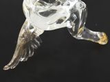 an antique glass figurine of a bird with wings on a black background