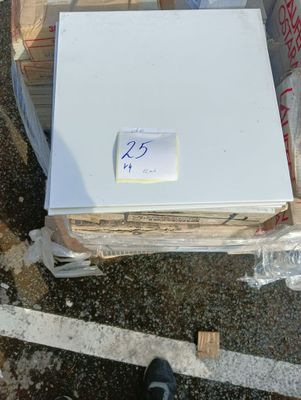 un réfrigérateur blanc posé sur une pile de cartons