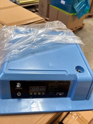 une boîte bleue surmontée d'une horloge, dans un entrepôt